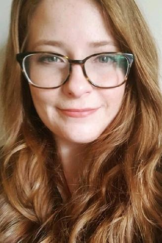 A woman with glasses and long red hair